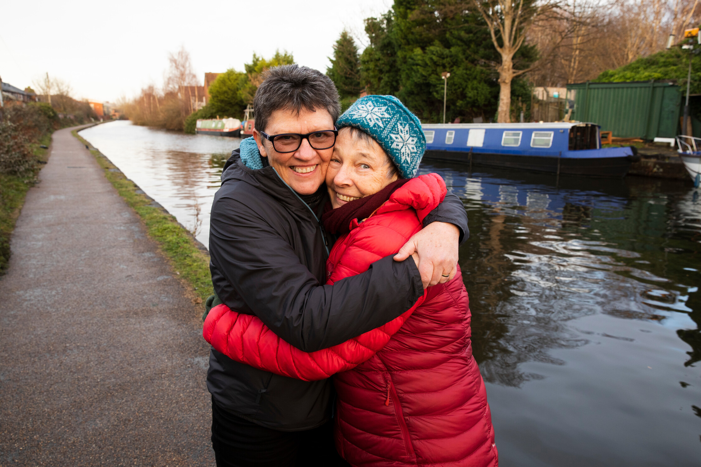 Two women hugging beside a canal