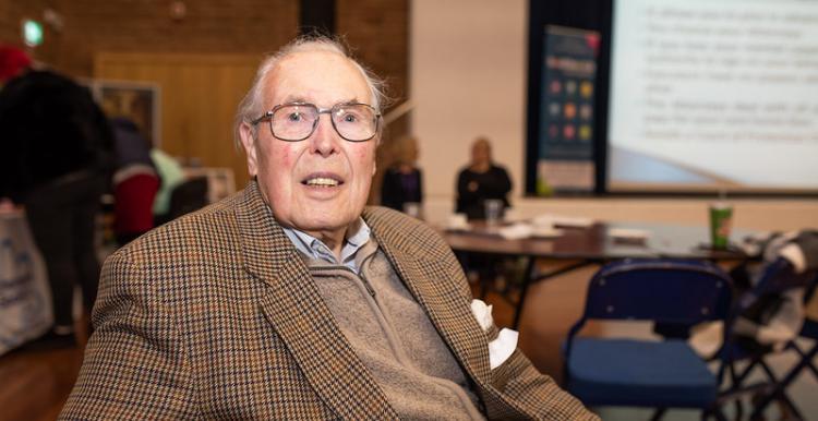 older gentleman in suit jacket sitting in office