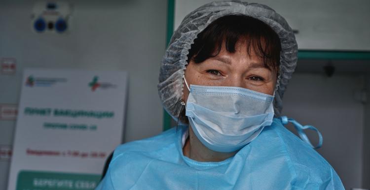 A female patient in a mask and scrubs in a hospital 