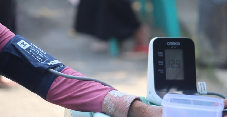 An arm stretched out with a blood pressure cuff and monitor