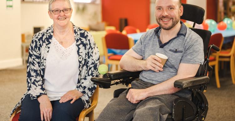 A man in a wheelchair and a woman sitting together 