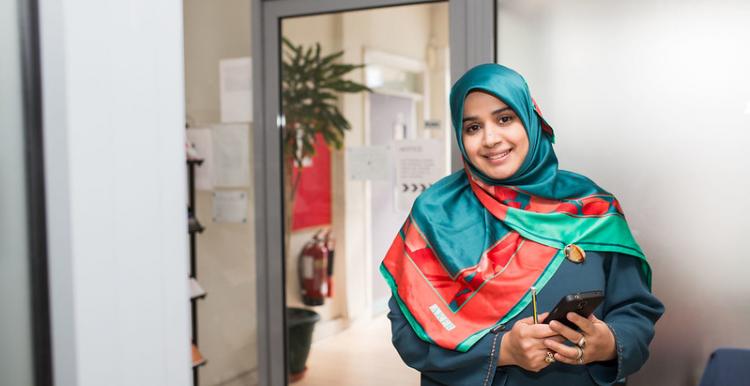 Woman wearing a headscarf holding a mobile phone