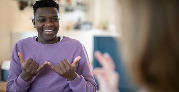 A boy and girl have a conversation in sign language