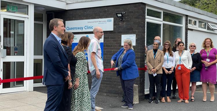 People queue up outside entrance to a building  