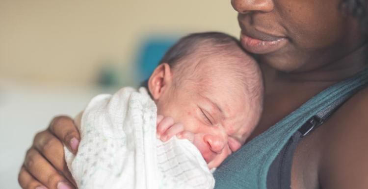 A woman holding a newborn baby