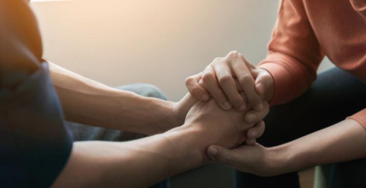 Two people hold hands