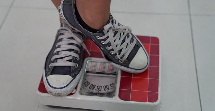 A pair of trainers standing on weighing scales A pair of trainers standing on weighing scales
