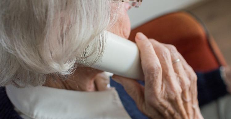 An elderly women speaks on the phone 
