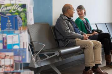 An elderly man and woman sitting in a waiting room