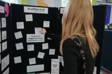 young person adding a post-it to an ideas board 