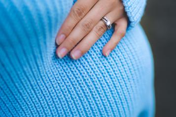 A pregnant woman in a blue jumper 
