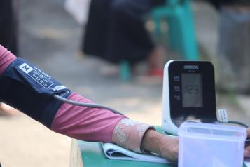 An arm stretched out with a blood pressure cuff and monitor