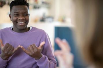 A boy and girl have a conversation in sign language 