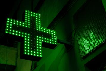 A green lit up pharmacy sign 