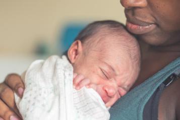 A woman holding a newborn baby