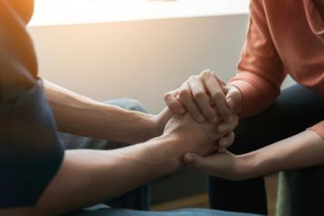 Two people hold hands 