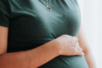 A pregnant woman in a grey T shirt 