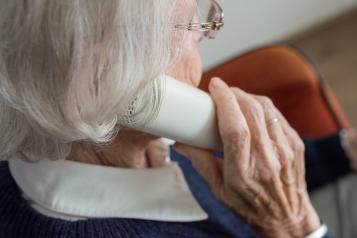 An elderly women speaks on the phone 