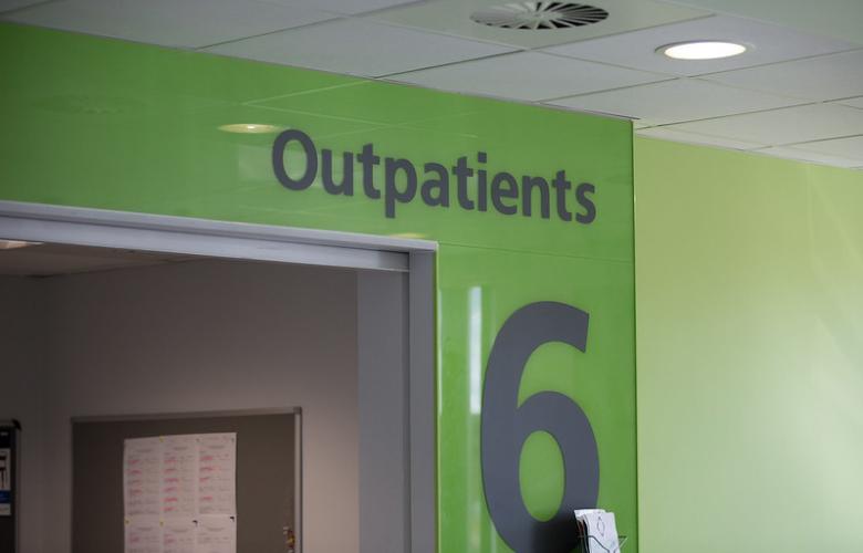 A green wall with a large number 6 and a sign that reads Outpatients